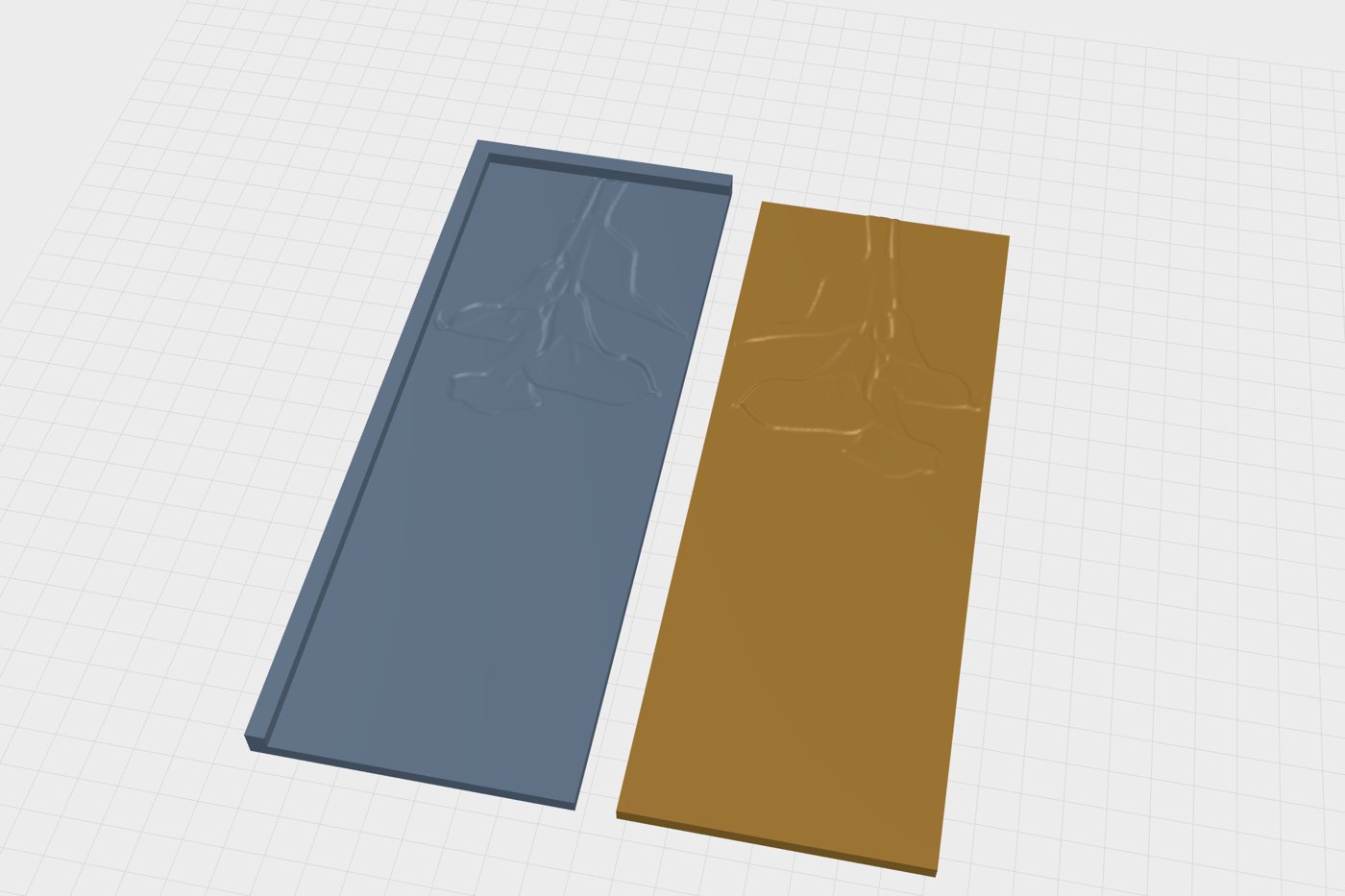 Two flat folder plates with stops along their edges and a sunflower relief